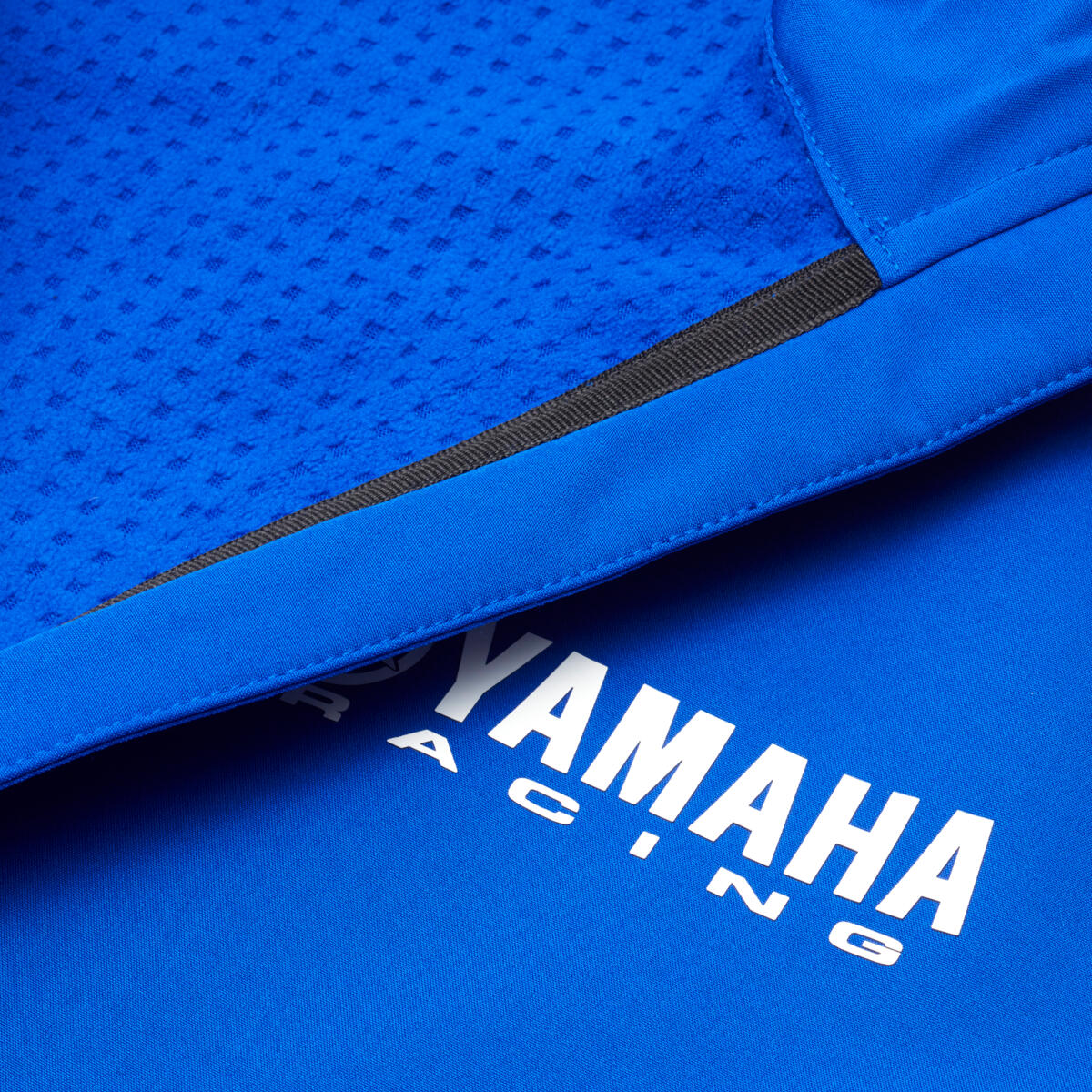 Die Paddock Blue Softshell-Jacke hat eine feste Kapuze und ein Fleece-Futter, das an windigen Tagen für zusätzliche Wärme und Komfort sorgt. Die hochwertige Softshell-Jacke trägt Yamaha Racing-Logos auf Brust und Ärmeln und verfügt über verschiedene kontrastierende Designelemente in Schwarz und Weiß.